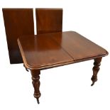 A Victorian mahogany pull-out extending dining table with two additional leaves, raised on fluted