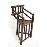 An early 20th century child's turner's chair with ring turned elbows, triangular seat and turned