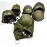 Four armoured vehicle crew helmets, three with fitted headphones and communication accessories,