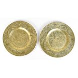 A pair of Chinese polished bronze chargers decorated with dragons within a Greek Key border and with