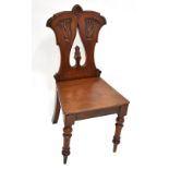 A Victorian mahogany hall chair with pierced and carved foliate motif back on turned front