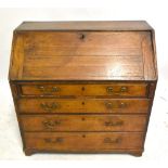 A Georgian oak bureau, the fall front enclosing fitted compartments and drawers, above one short and