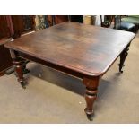 A large Victorian mahogany wind-out extending dining table with two extra leaves, raised on turned