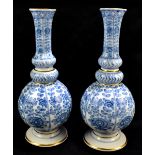 MEISSEN; a pair of 19th century blue and white onion vases, painted with floral sprays inside panels