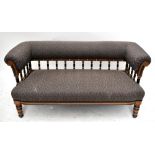 A late 19th century Aesthetic Movement walnut and ebonised salon settee with padded back rail and