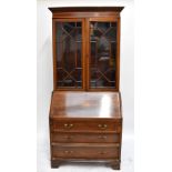 An Edwardian inlaid mahogany bureau bookcase, the twin astragal glazed doors enclosing three