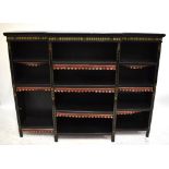 An Aesthetic Movement ebonised breakfront bookcase with impressed gilt detail above an arrangement