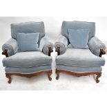 A pair of reproduction walnut framed upholstered armchairs with carved detail to the front rail