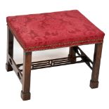 An early 20th century mahogany Chinese Chippendale-style foot stool with padded top above square