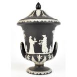WEDGWOOD; a black and white jasper dip urn and cover relief decorated with Classical figures, with