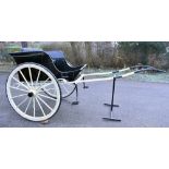 A large painted Governess cart with fourteen spoke wheels, padded seat and back rest.