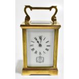 A brass cased carriage clock, the white enamelled dial set with Roman numerals above detail for