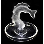 LALIQUE FRANCE; a clear and frosted glass pin dish decorated with a leaping fish, signed to base,