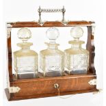 An oak three bottle tantalus with hallmarked silver mounts for James Dixon & Sons, Sheffield 1903,