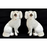 A pair of late 19th century Staffordshire spaniels with freestanding front legs and part textured