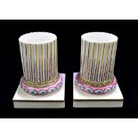 DERBY; a pair of 18th century pillars of fluted design, gilt heightened with pink ground on square