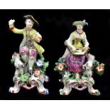 DERBY; a pair of 18th century figures, she with dancing dog by her feet and playing a musical