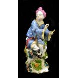 CHELSEA; an 18th century red anchor period figure of a seated Oriental gentleman wearing a puce