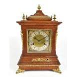 A 19th century oak cased German mantel clock, with applied brass urn surmounts and beaded decoration