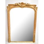 A 19th century carved giltwood framed over-mantel mirror, the arched plate inside a beaded and