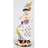 MEISSEN; a 19th century figure of a girl wearing a hat and holding a cushion wearing crinoline-