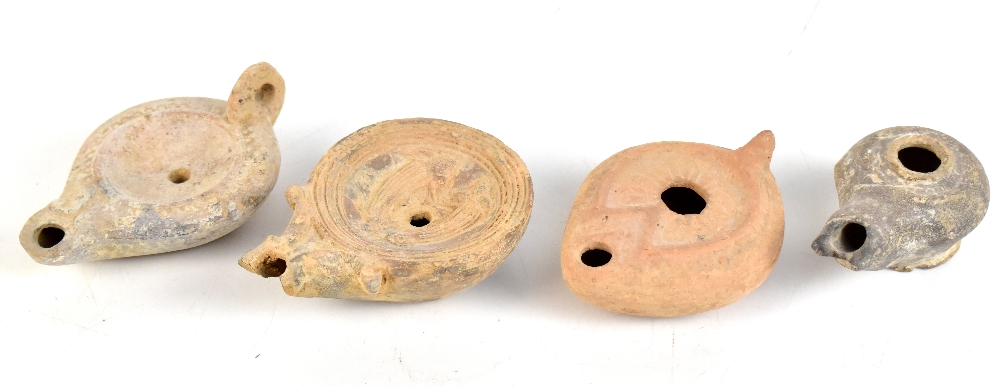 Three Roman terracotta oil lamps, one of circular form with embossed decoration, length of largest