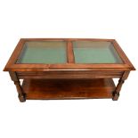 A reproduction stained pine bijouterie coffee table of rectangular form with two end drawers above