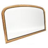 A modern gilt framed oval over-mantel mirror with slightly arched reeded frame and bevelled plate,