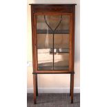An Edwardian mahogany, stained beech and boxwood line-inlaid single door display cabinet raised on