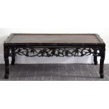 An early 20th century Chinese hardwood low coffee table with leaf and berry decorated pierced frieze