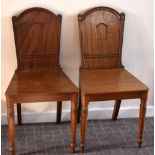 A pair of Victorian walnut hall chairs, each back with fluted uprights and central recessed panel
