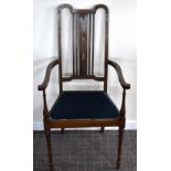 An Edwardian stained beech and inlaid elbow chair with padded seat and turned front legs.