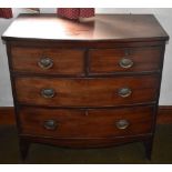 An early 19th century mahogany bowfronted chest of two short and two long drawers raised on