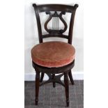 An early Victorian mahogany cellist chair with bar back above lyre splat, rise and fall screw action