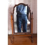 An early 20th century walnut swing toilet mirror with shaped plate and simple square section