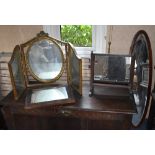 A gilt framed triptych dressing table mirror, an oval mahogany line inlaid wall mirror with bevelled