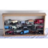 A modern small table top display case containing fifteen tin plate vehicles, including Corgi