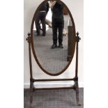 An Edwardian mahogany and chevron strung cheval mirror with oval plate held by turned uprights to