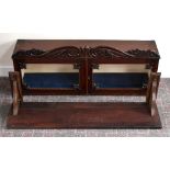 An early Victorian mahogany cabinet with carved pediment above two glazed doors mounted on an