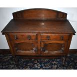 A 1920s oak sideboard of small proportions with raised back above two drawers and two cupboard