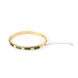A 9ct gold hinged bangle, channel set with four green jade panels and rope twist edging,