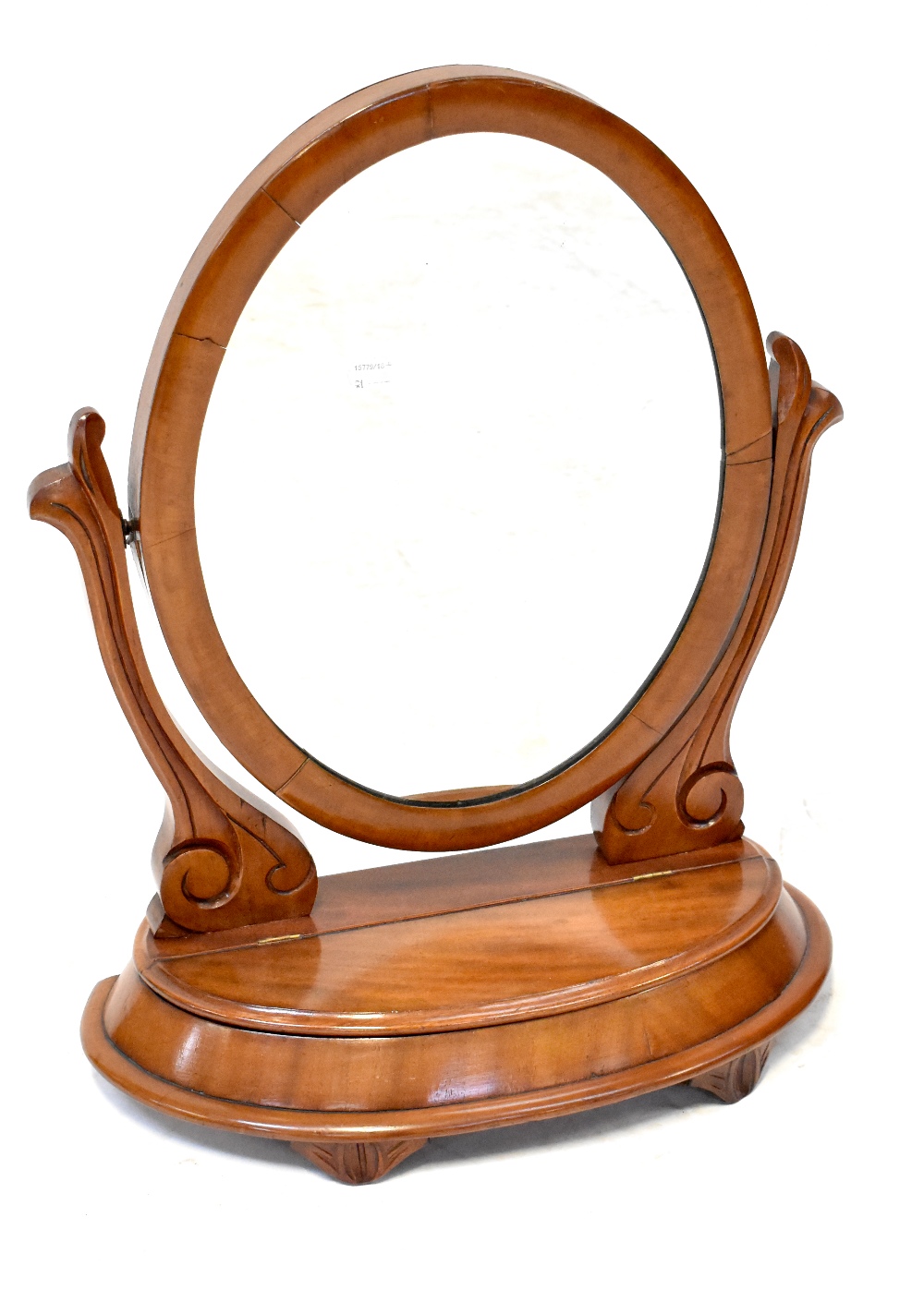 A Victorian mahogany swing toilet mirror with oval mirror plate on scroll supports,