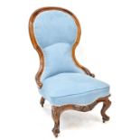 A Victorian walnut spoon back nursing chair, upholstered in a light blue velure,