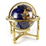 A hardstone globe on a brass-effect stand, united by a cross-stretcher mounted with a compass,
