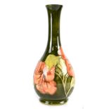 A Walter Moorcroft green ground 'Hibiscus' pattern bulbous vase with slender flared neck,
