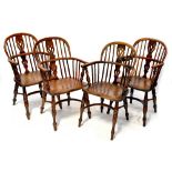 A set of four 18th century yew Windsor chairs with pierced splat backs flanked by simple spindle