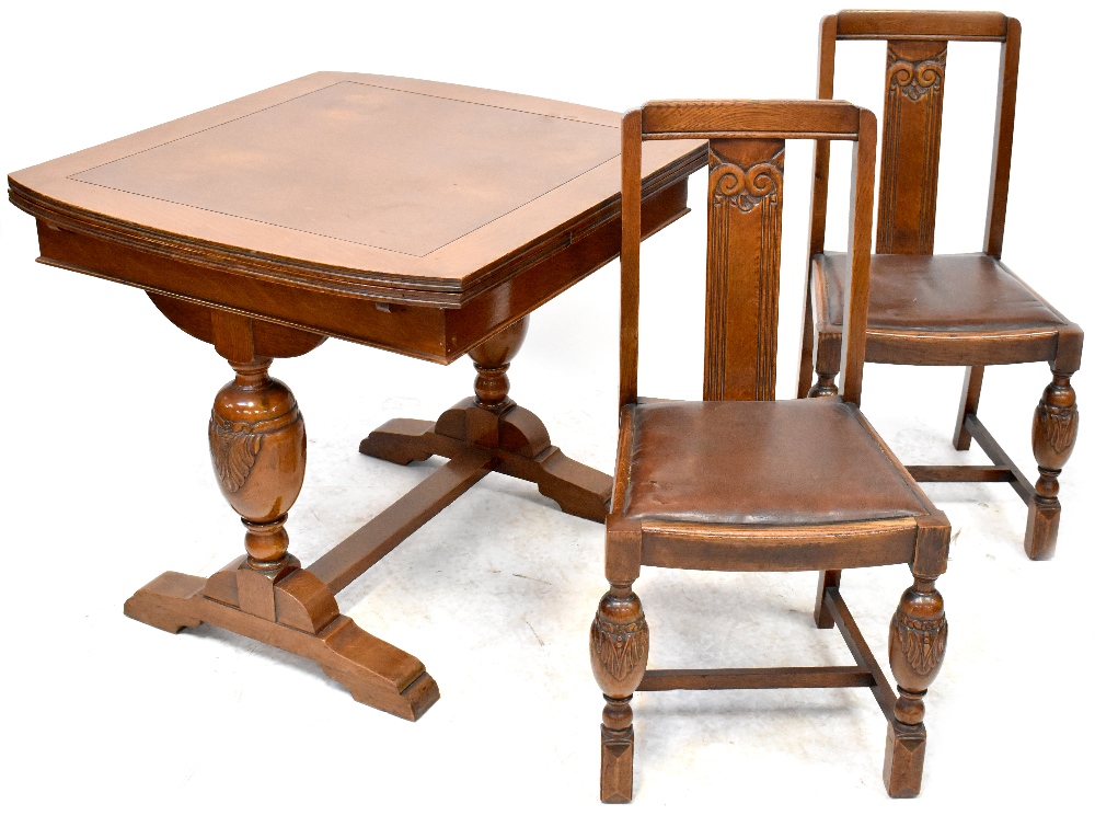 An early 20th century oak dining suite comprising a draw leaf table,