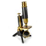 A cased brass and lacquered metal microscope, stamped trademark with an eye, height 26cm.