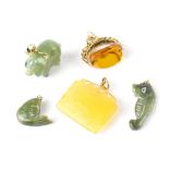 Three carved green jade-style necklace pendants to include a pig, a seahorse and a carp,