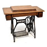 A Jones treadle sewing machine and table, oak top with hinged lid enclosing machine,